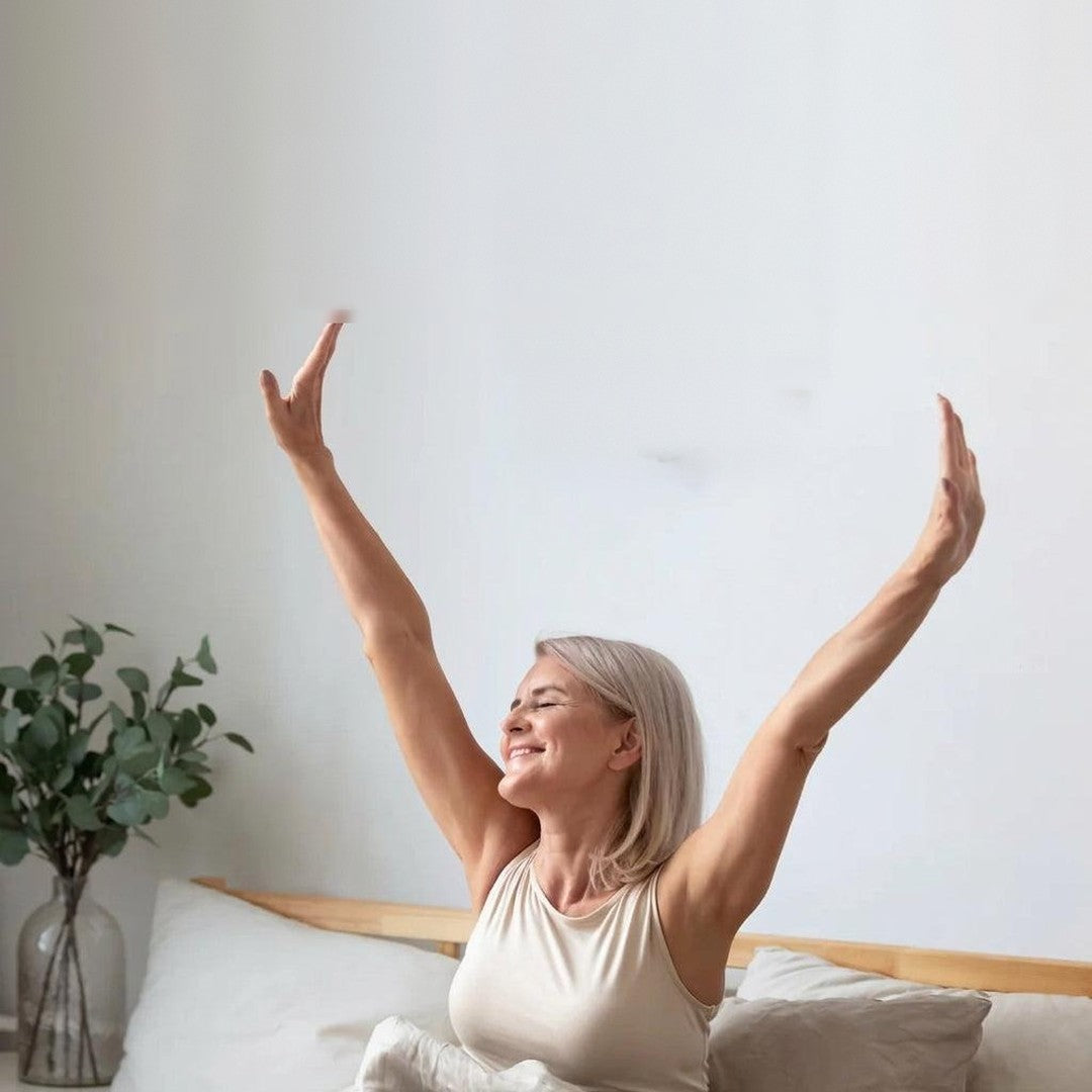 Frau streckt sich morgens erholt im Bett